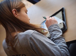 Student using iPad in school. Image via Flickr by Flickingerbrad.